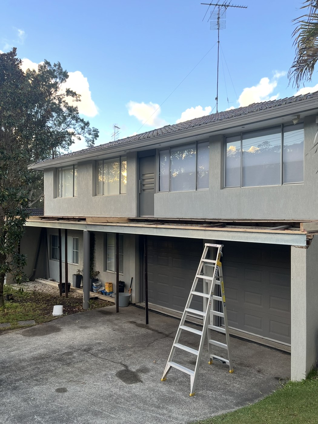 Before: bare timber deck frame under the upper balcony