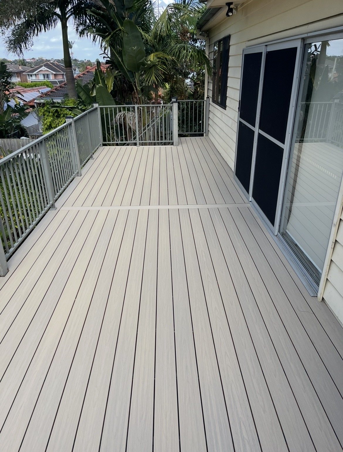 After: finished light grey composite deck with new balustrade