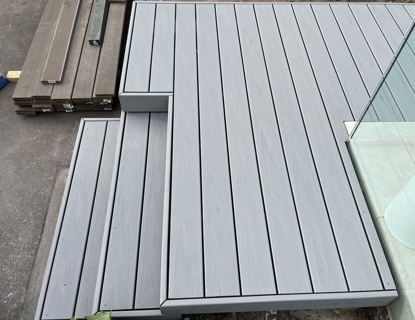 Grey composite deck under construction beside the pool