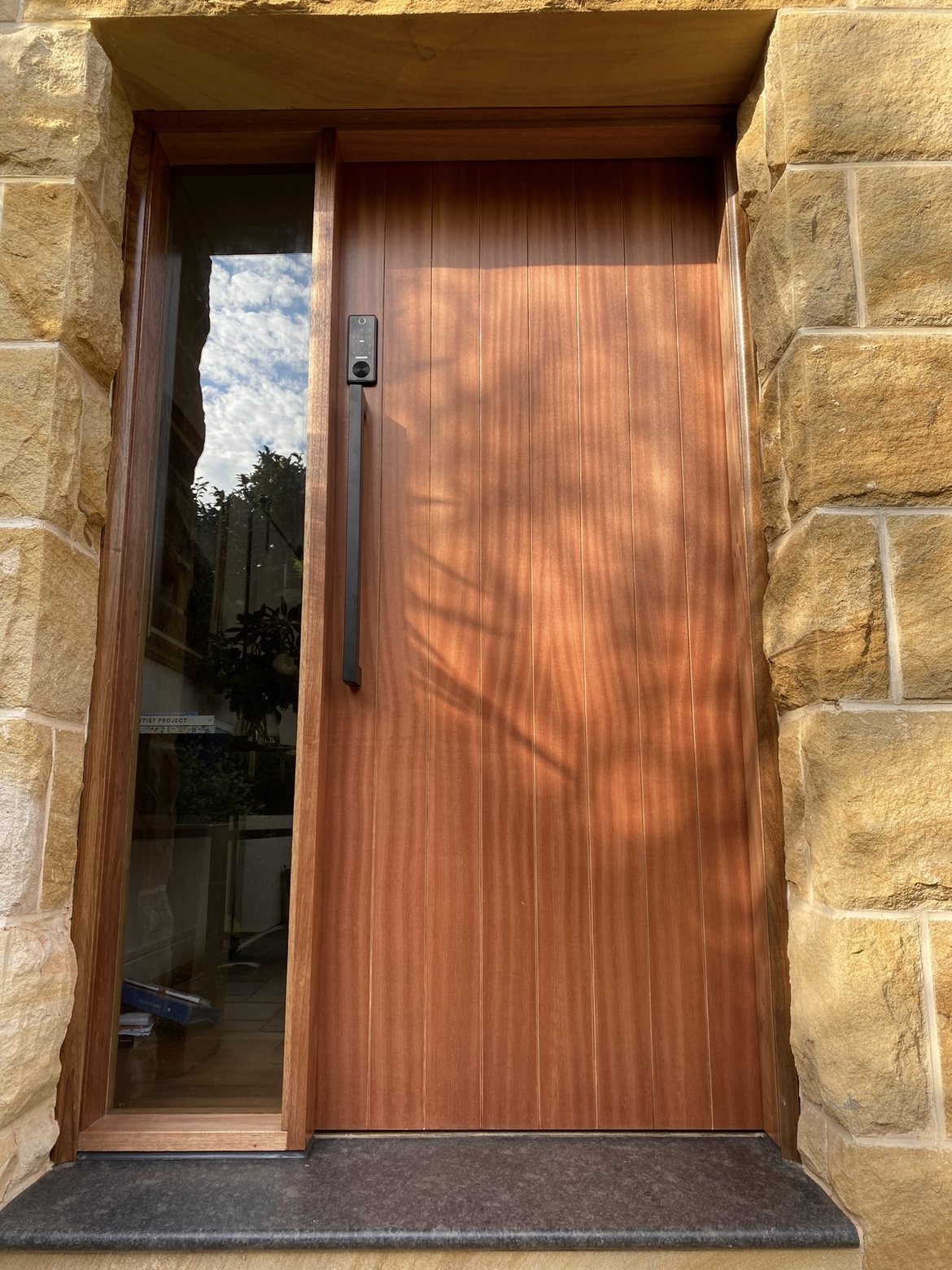 Mahogany vertical slat front door, sandstone surround