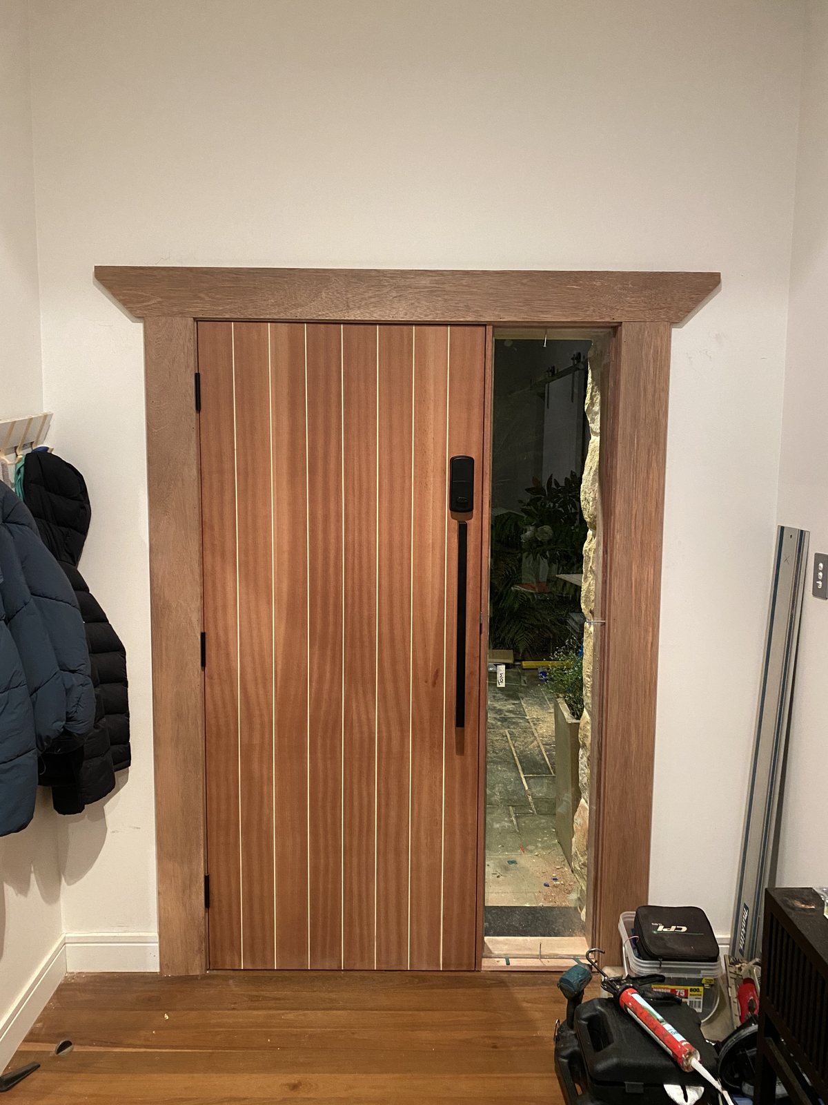 Mahogany slat door seen from the entry hallway inside