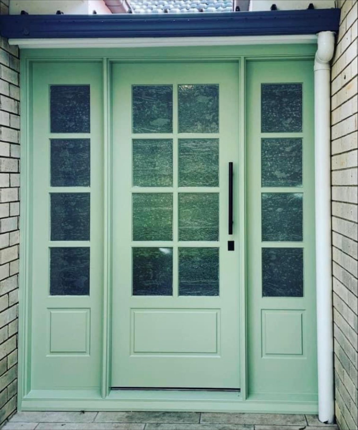 Mint green front door with multi-pane sidelights