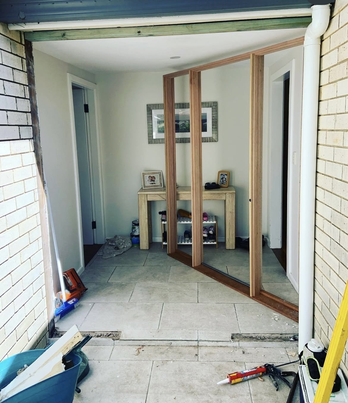 Before: timber-framed glass entry door mid-installation
