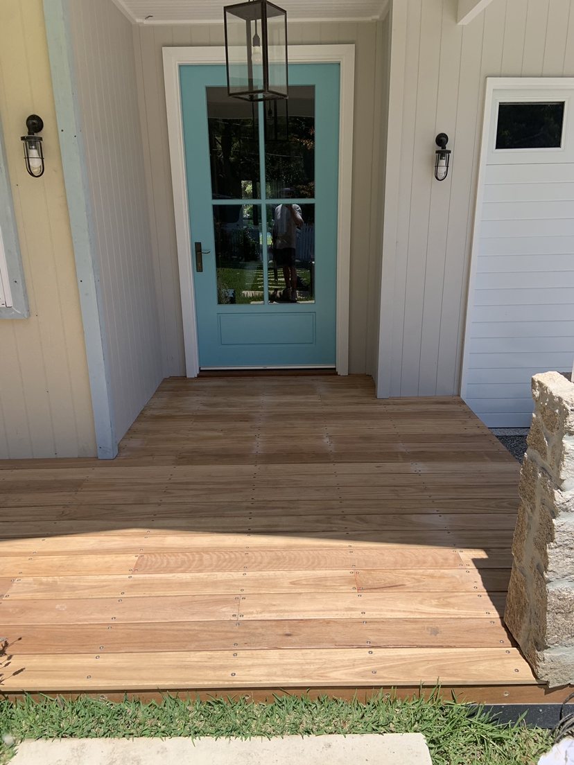 Teal stable-style door with lantern light and deck