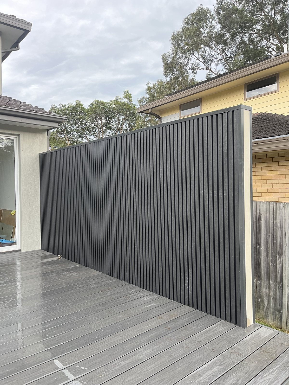 Black vertical slat privacy wall on a deck