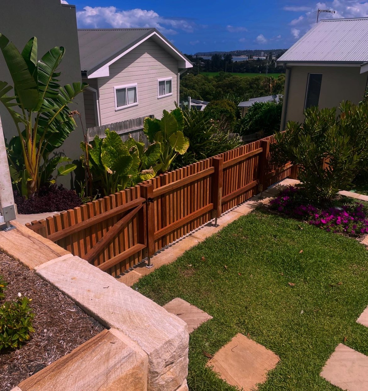 Slat fence and gate with coastal water view