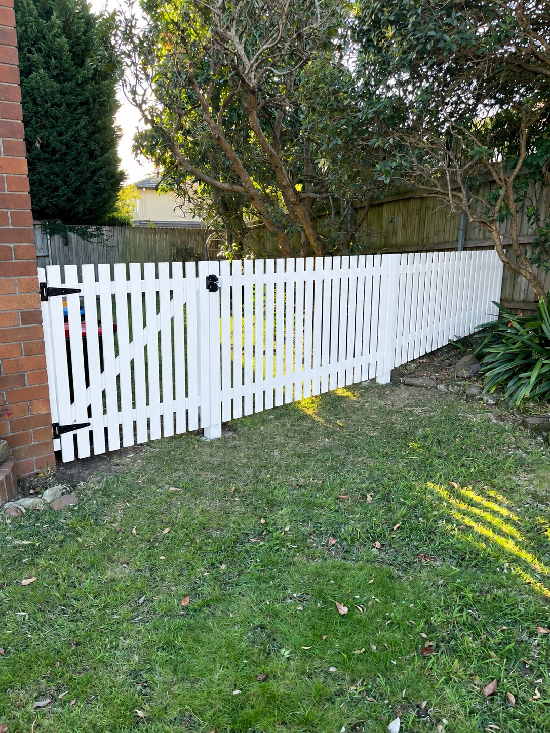 After: white picket fence and gate dividing the side yard