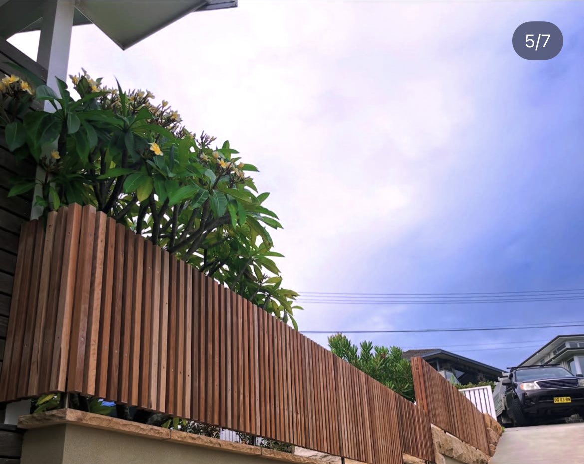 Spotted gum fence with sandstone wall, driveway view