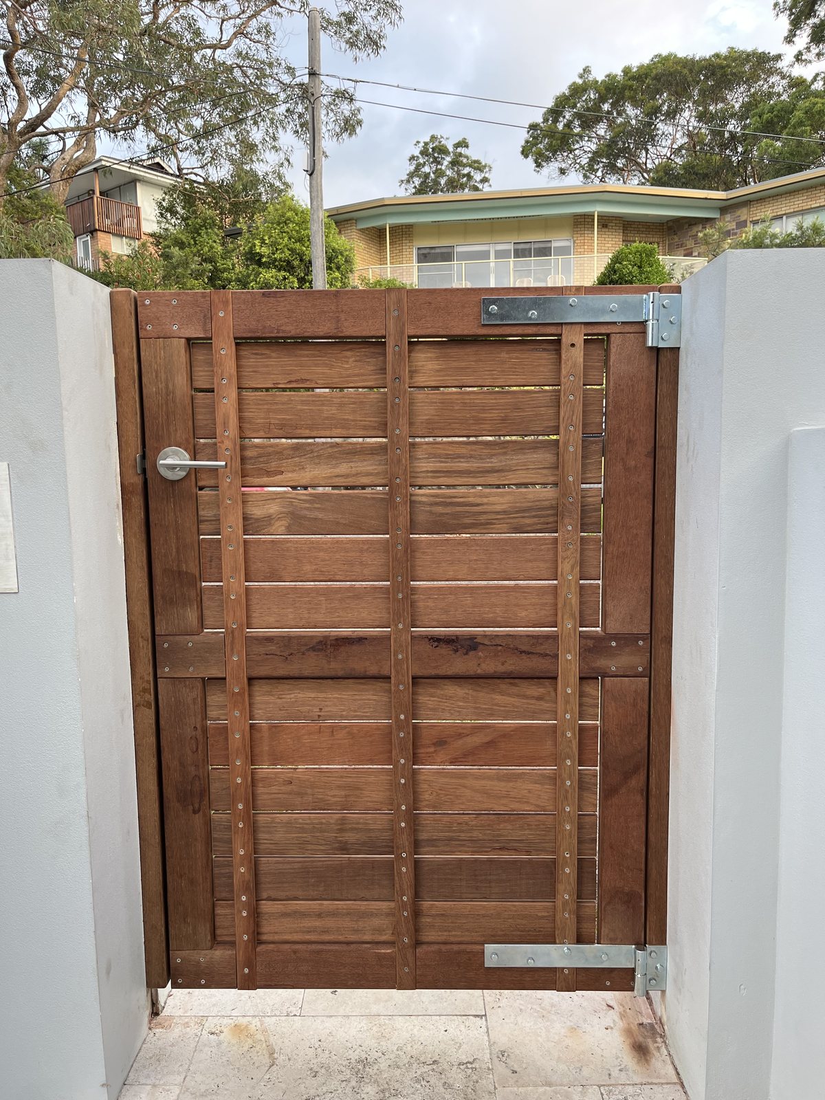 Horizontal slat timber gate with white posts