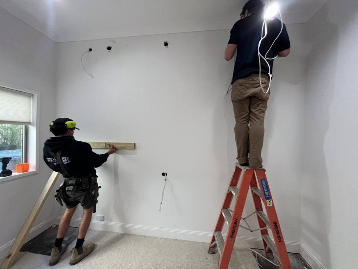 Before: tradesmen marking out a bare wall