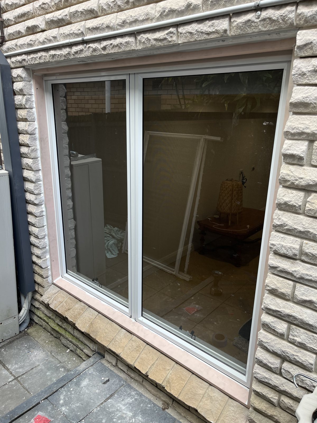 Sliding glass door set into a sandstone exterior wall
